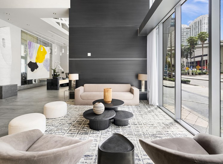 A modern living room with a large window overlooking the street.
